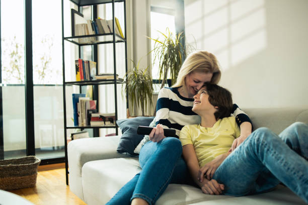 istock Mother cuddling and watching TV on the sofa with her son 1483526024