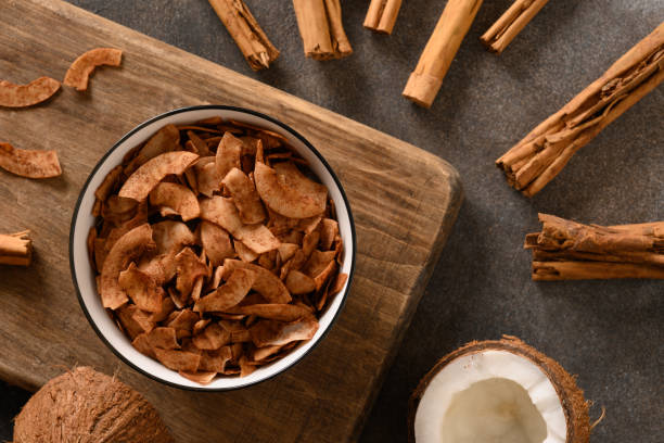 istock Coconut chips with cinnamon in bowl on brown. Vegan and sugar free snack. 1483528193