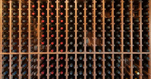 Wine rack with bottles for tasting at a winery. Useful background image, all maker's marks removed. Shot in ambient light.