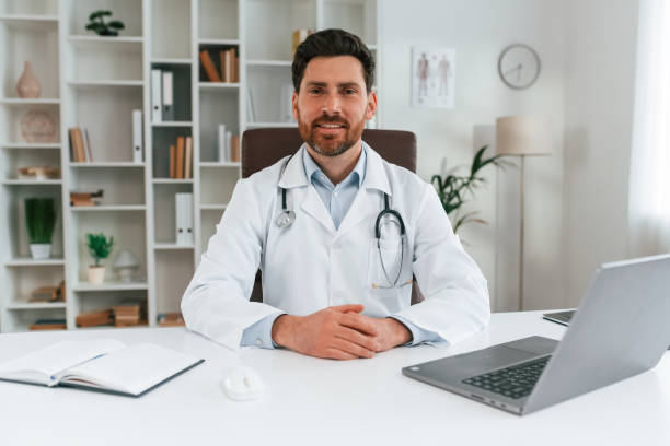 istock Sitting by a table. Doctor in formal clothes is working in the cabinet 1483531279
