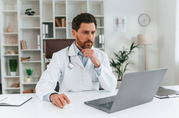 istock Sitting by a table. Doctor in formal clothes is working in the cabinet 1483531291