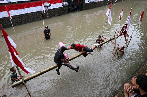 Denpasar, bali - august 17, 2018: pillow hitting competition on the river in welcoming the independence day of the republic of indonesia