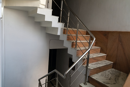Brown stairway with simple stainless steel railings. Indoor. Home. Office. Empty.
