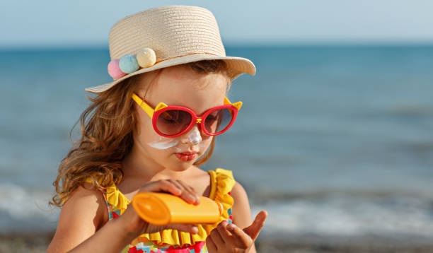 istock The child holds a bottle of moisturizing Sunscreen in his hands and puts a protective layer on her face. 1483538876