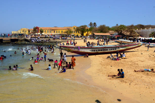 The 'petite plage', Gorée Island's most central and main beach, Dakar, Senegal Gorée Island, Dakar, Senegal: the 'Petite Plage', small beach with golden sand, protected by the harbor piers and located downtown, in front of Government Square - Buildings of Human Rights square in the background - East coast of Gorée Island. senegal beach stock pictures, royalty-free photos & images