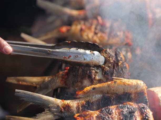 istock Selective focus of cooking fish. Baking and roasting marinated fish on barbecue grill. Thunnini grilled over charcoal. Summer barbeque hand marinade the fish. 1483541041