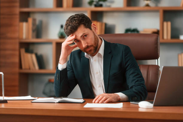 istock Tired, feeling bad. Businessman in formal clothes is working indoors 1483542671