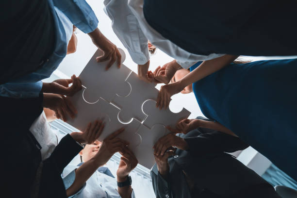 Diverse corporate officer workers connecting puzzle pieces. Concord