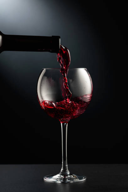 istock Pouring red wine into a wine glass. 1483544871