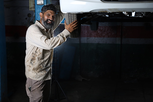 Mechanic repairing car at the car service station using right equipments and tools