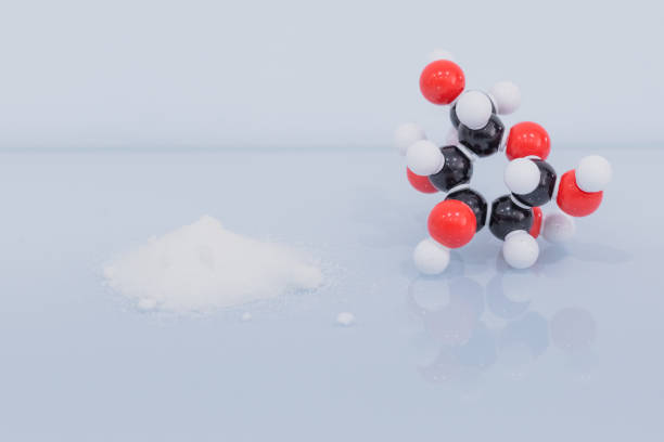 istock Isolated glucose molecule made by molecular model next to a little heap of white sugar. 1483548905