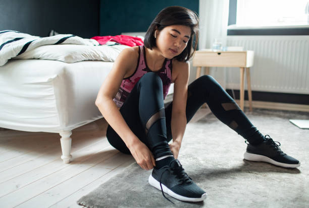 istock Young woman tying her shoelaces and getting ready to go exercise 1483549046