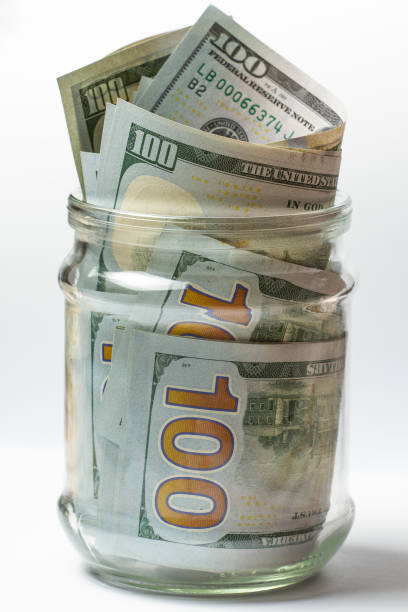 istock glass jar with hundred-dollar bills, savings, security. 1483555569