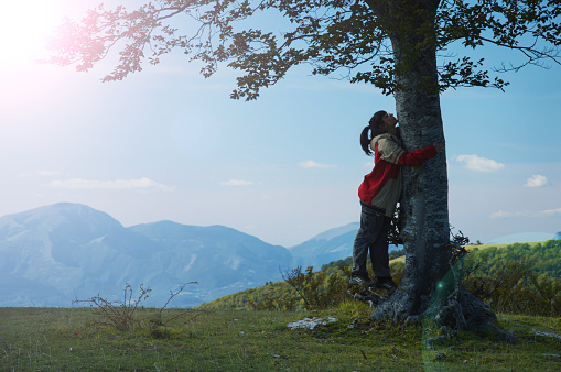 Girl hug a beech tree, nature friendly people, sustainable lifestyle concept