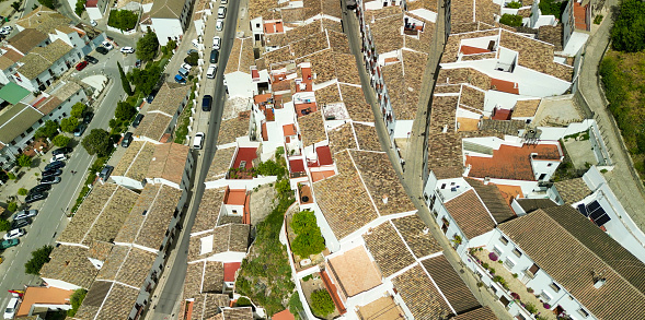 Zahara de la Sierra, Andalusia. Aerial view of whitewashed houses sporting rust-tiled roofs and wrought-iron window bars, Spain