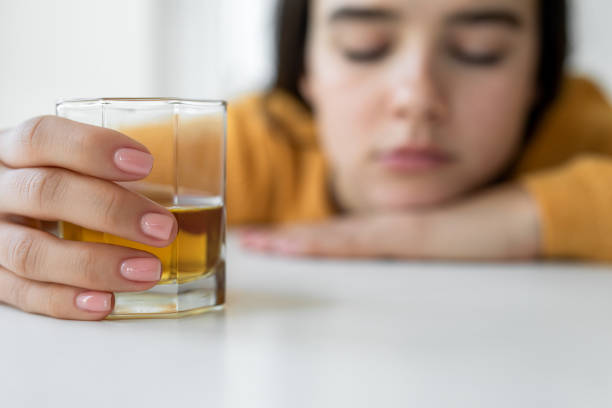 istock Upset woman drinker alcoholic sitting with drinking whiskey alone 1483562686