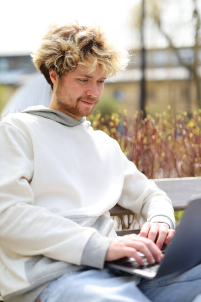 istock Portrait of a curly-haired student working on a laptop on campus. 1483562756