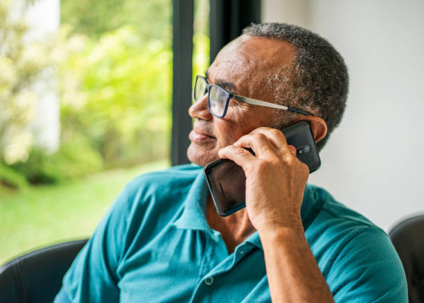 istock Smiling senior man talking on his mobile phone at home 1483563648
