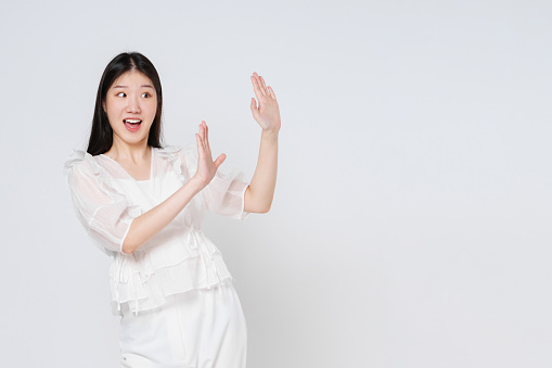 Young woman act like a pushing something isolated on white background. Surprised happy woman looking copy space in excitement. Presenting some product.