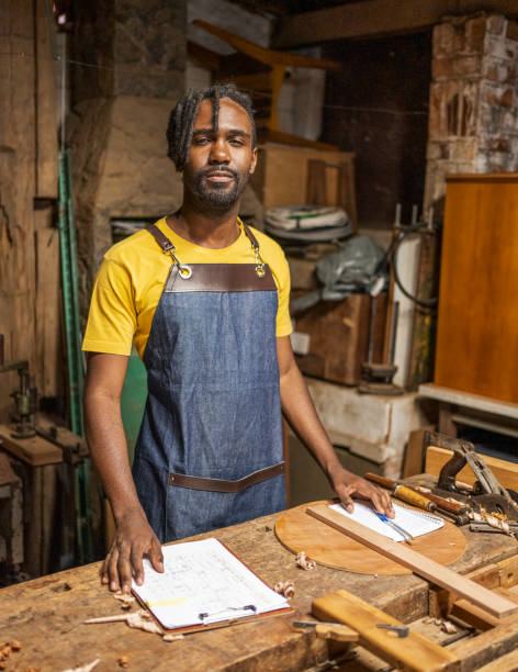 istock Young man standing at a bench in a woodworking shop 1483566489