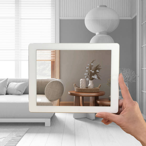 istock Augmented reality concept. Hand holding tablet with AR application used to simulate furniture products in custom architecture design, total white background, japandi living room 1483567226