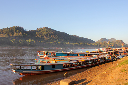 Luang Prabang, Laos - December 2012: Wooden canoes and boats anchored on the banks of the Mekong river in the beautiful town of Luang Prabang.