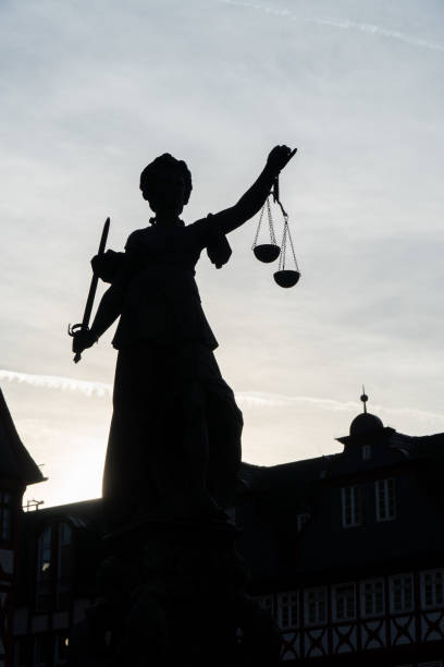 istock Backlit monument of Lady Justice with a blue sky in the background 1483569092