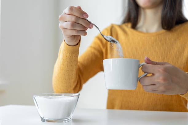 istock Woman adding sugar to hot drink 1483571876