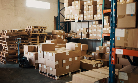 Storage, empty warehouse and boxes in factory, cargo and shipping logistics of production. Backgrounds, stock and commercial store space in manufacturing plant, supply chain industry and distribution