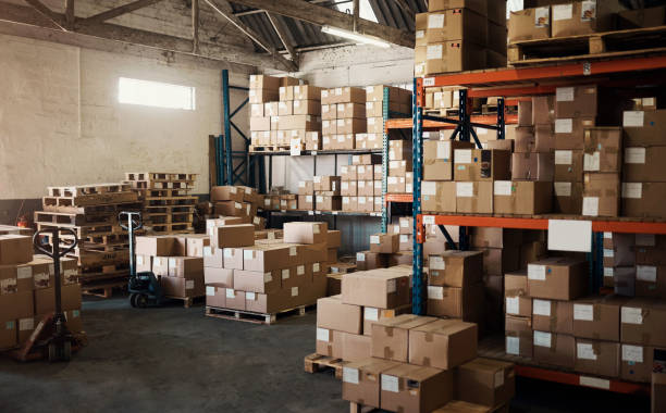 istock Factory space, empty warehouse and boxes for delivery, courier or shipping logistics in storage room. Backgrounds, stock and commercial package for distribution, supply chain industry or cargo export 1483571899