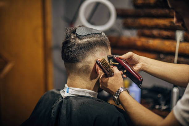 istock A barber cuts a client's hair in a barbershop 1483572005