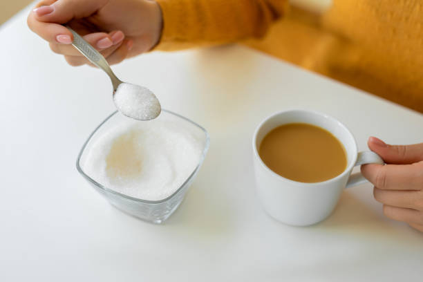 istock Hand is pouring sugar to cup of coffee 1483572075