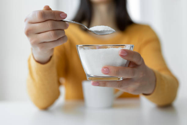 woman adding refined sugar to cup of coffee - sugar imagens e fotografias de stock