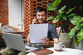 istock Asian Man Discussing Financial Document with Client via Phone Call 1483577166