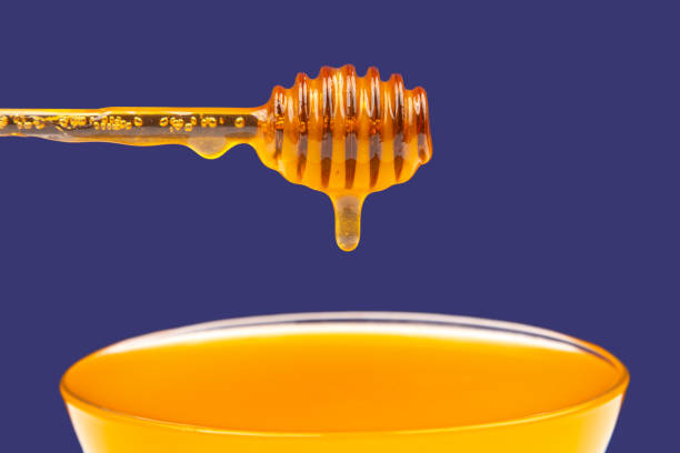 istock fresh fragrant honey dripping from a spoon into a plate on a blue background. organic vitamin nutrition 1483582834