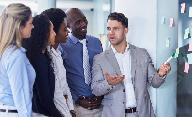 istock Businessman sharing idea with mindmap, team and presentation, planning and strategy with sticky note. Coaching, goals and ideas on moodboard and creative man with vision working on project in office. 1483591052