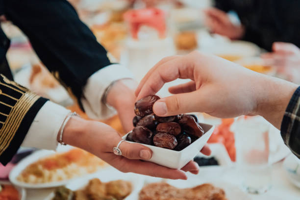 istock Modern multiethnic muslim family sharing a bowl of dates while enjoying iftar dinner together during a ramadan feast at home 1483593603