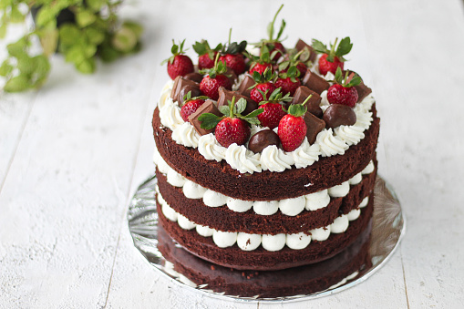 Tasty chocolate cake with butter cream and strawberry toppings