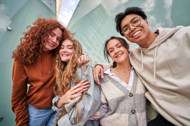 istock Group photo of cheerful young multiracial couples looking at camera outdoors. Low angle. 1483594748