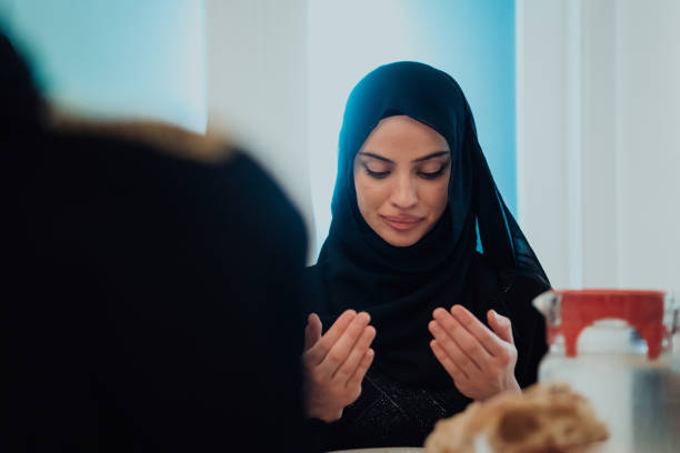 istock Muslim woman making iftar dua to break fasting during Ramadan. 1483595488