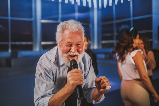 business people singing karaoke in a night club and celebrate a birthday
