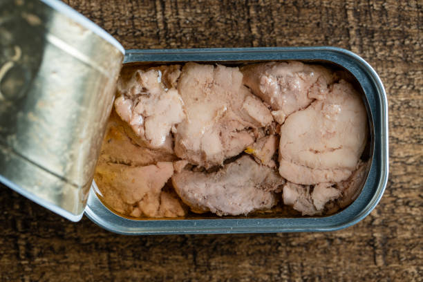 istock Open tin can with cod liver on wooden table background, closeup, top view 1483596281
