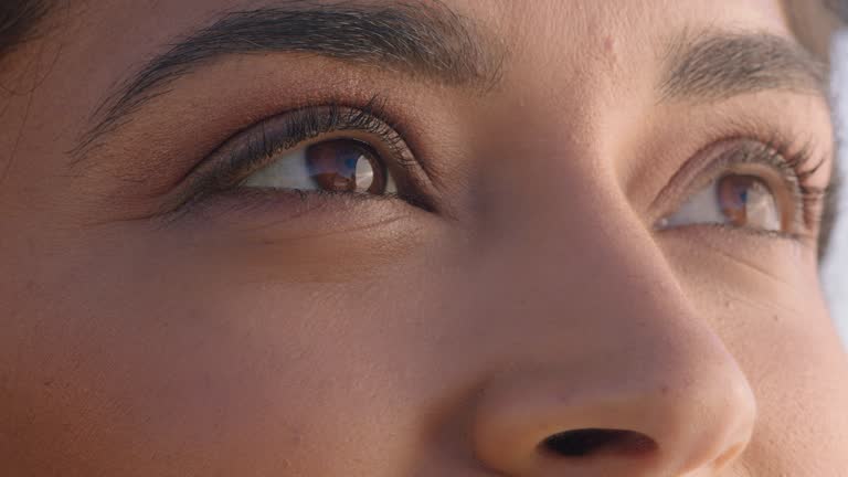 close up beautiful eyes hispanic woman looking at ocean view enjoying natural beauty contemplating future enjoying freedom