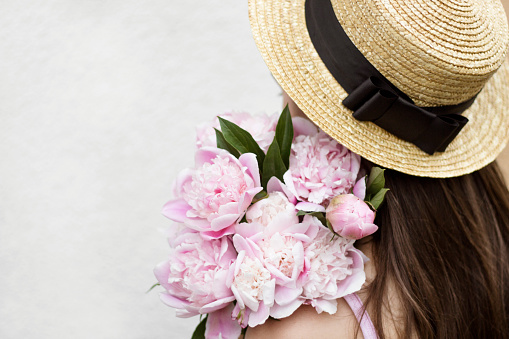 girl in a hat with a bouquet of peonies, boater hat with black ribbon, bridesmaid, greeting card with flowers