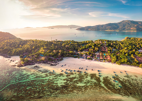 Panorama aerial view of beautiful Koh lipe island with tropical sea, fishing boat and resort on the beach in summer vacation at the sunset. Satun, Thailand