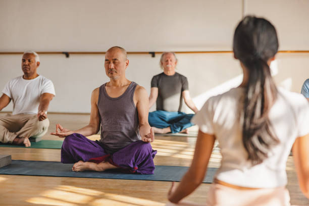 istock Mature Yoga Participants Meditating With Female Instructor 1483599574