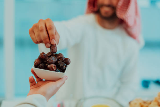 istock Modern multiethnic muslim family sharing a bowl of dates while enjoying iftar dinner together during a ramadan feast at home 1483606157