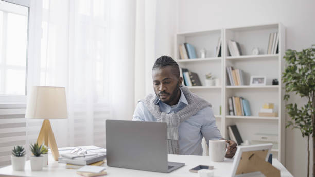 istock A concentrated African American man is a software developer working on his laptop in his office 1483611948