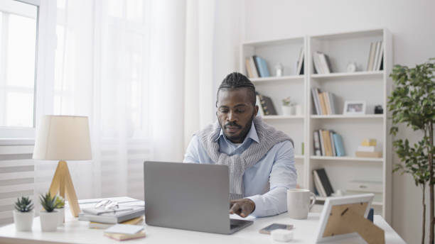 istock A stylish freelancer is working on his laptop in his comfortable home office, doing remote work 1483611950
