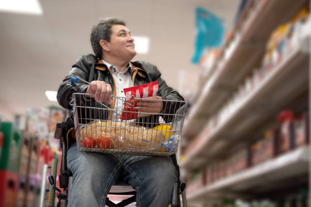 A disabled person in a wheelchair buys groceries stock photo